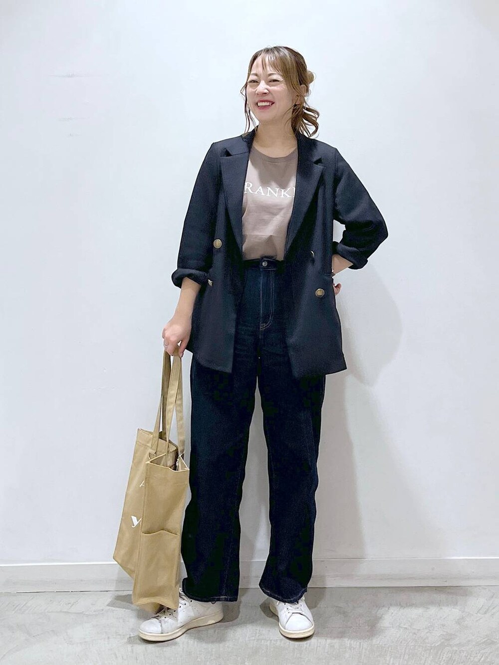 ブルー系のテーラードジャケット、ベージュ系のトートバッグ、ブルー系のデニムパンツを着用したレディースの春コーディネートの3枚目の写真