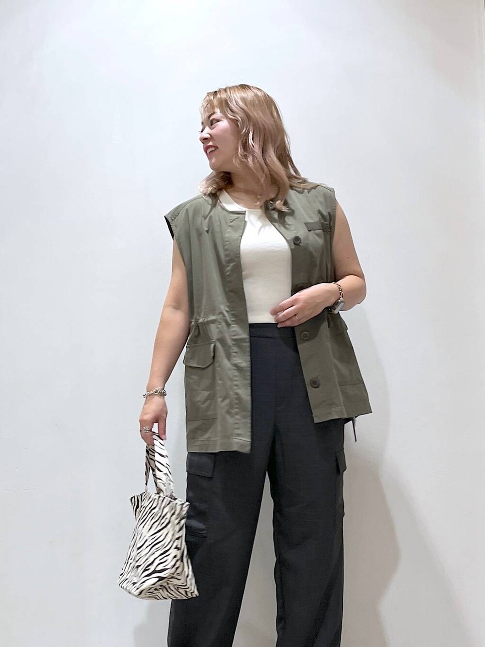 ホワイト系のタンクトップ、ブラック系のローファー、グレー系のカーゴパンツを着用したレディースの夏コーディネートの5枚目の写真