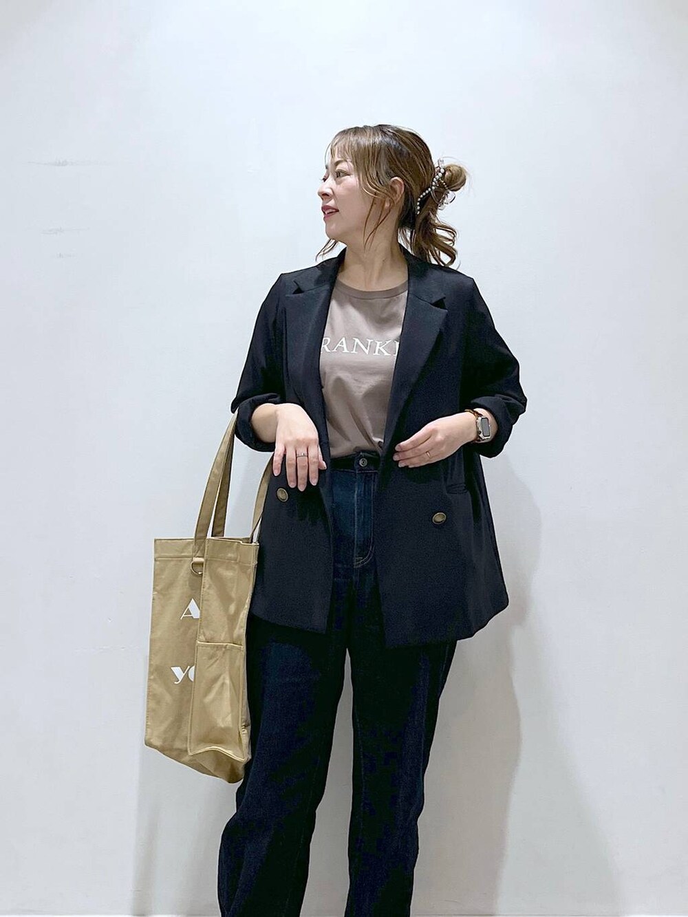 ブルー系のテーラードジャケット、ベージュ系のトートバッグ、ブルー系のデニムパンツを着用したレディースの春コーディネートの9枚目の写真