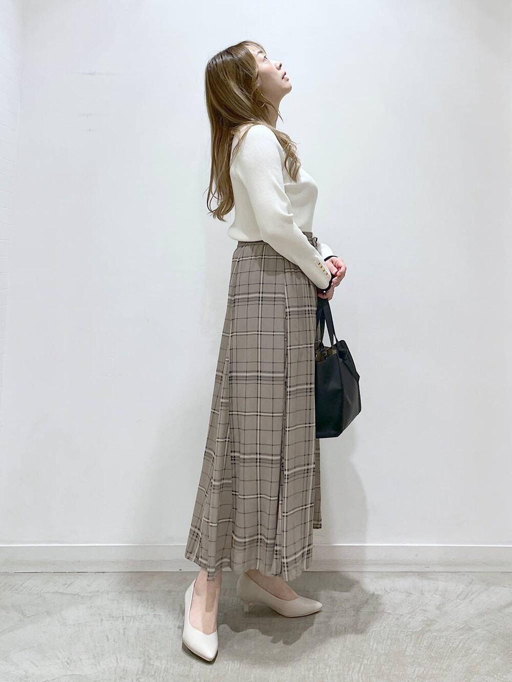 ホワイト系のTシャツ/カットソー、ホワイト系のパンプス、ブラック系のショルダーバッグを着用したレディースの春コーディネートの4枚目の写真