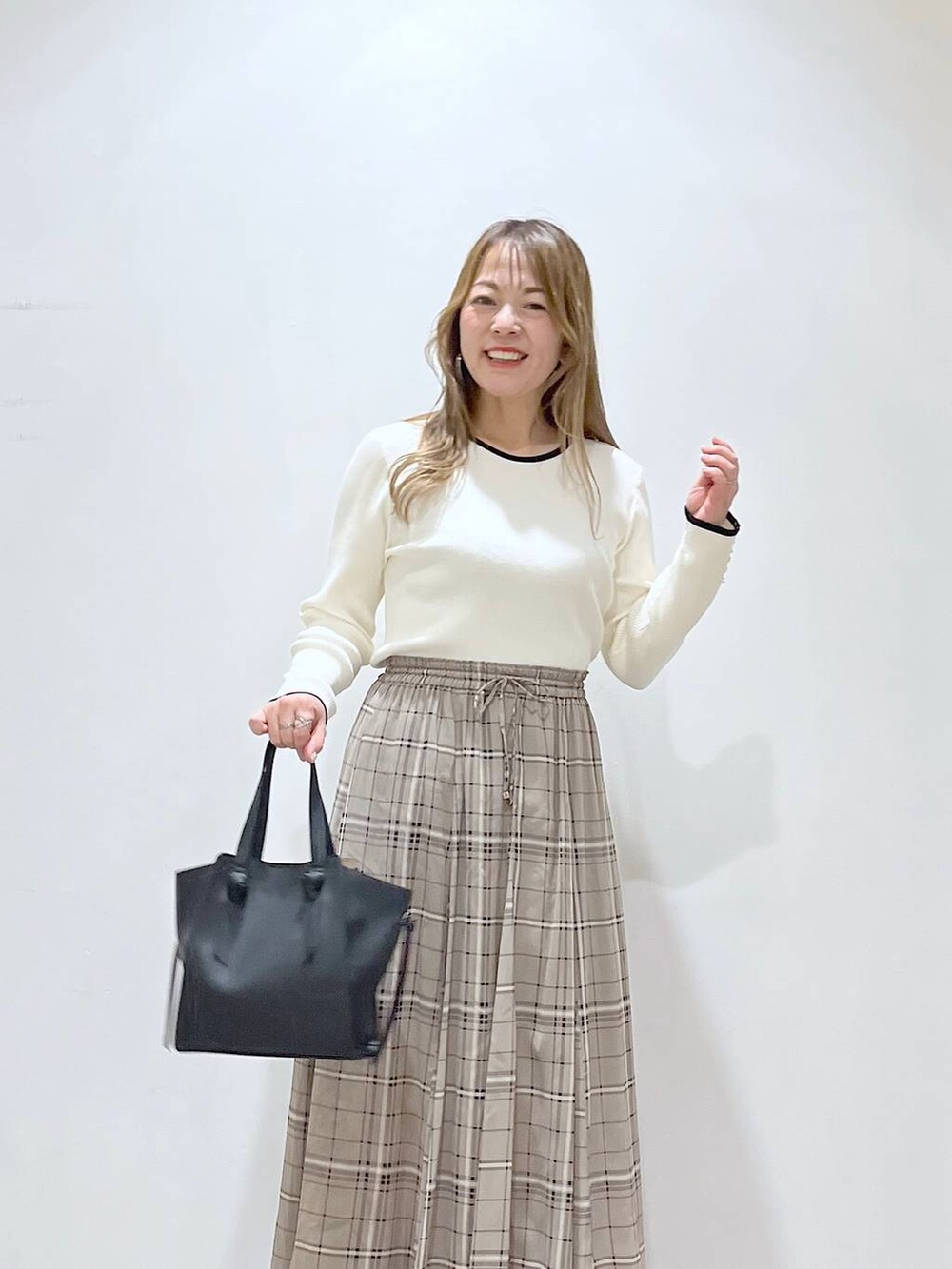 ホワイト系のTシャツ/カットソー、ホワイト系のパンプス、ブラック系のショルダーバッグを着用したレディースの春コーディネートの5枚目の写真