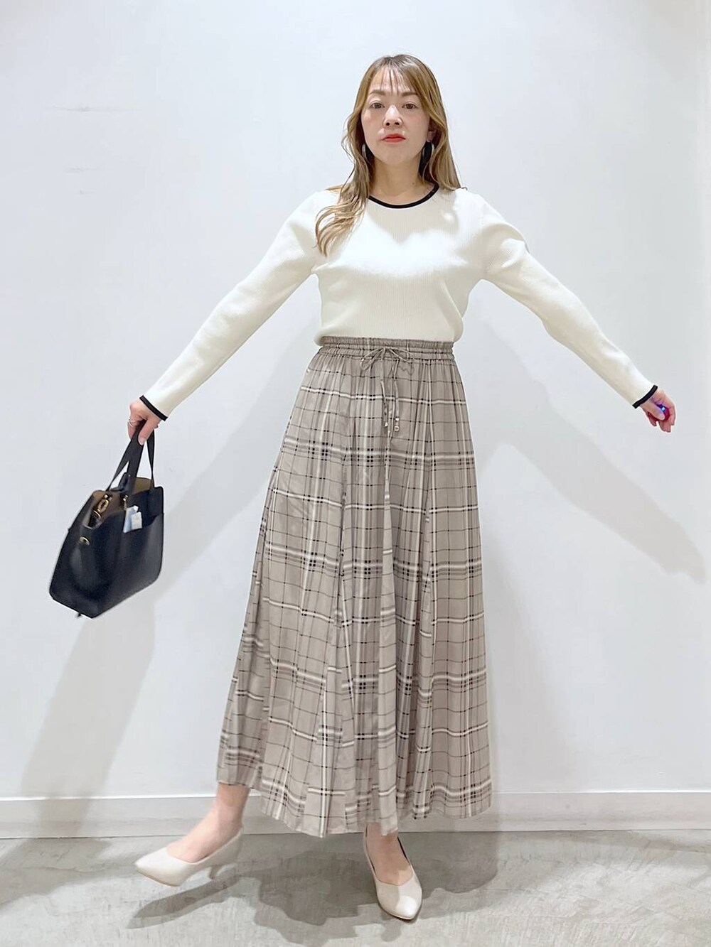 ホワイト系のTシャツ/カットソー、ホワイト系のパンプス、ブラック系のショルダーバッグを着用したレディースの春コーディネートの9枚目の写真