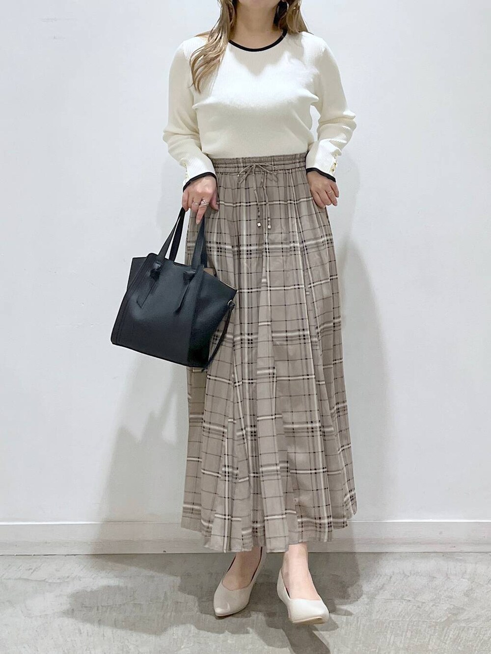 ホワイト系のTシャツ/カットソー、ホワイト系のパンプス、ブラック系のショルダーバッグを着用したレディースの春コーディネートの8枚目の写真