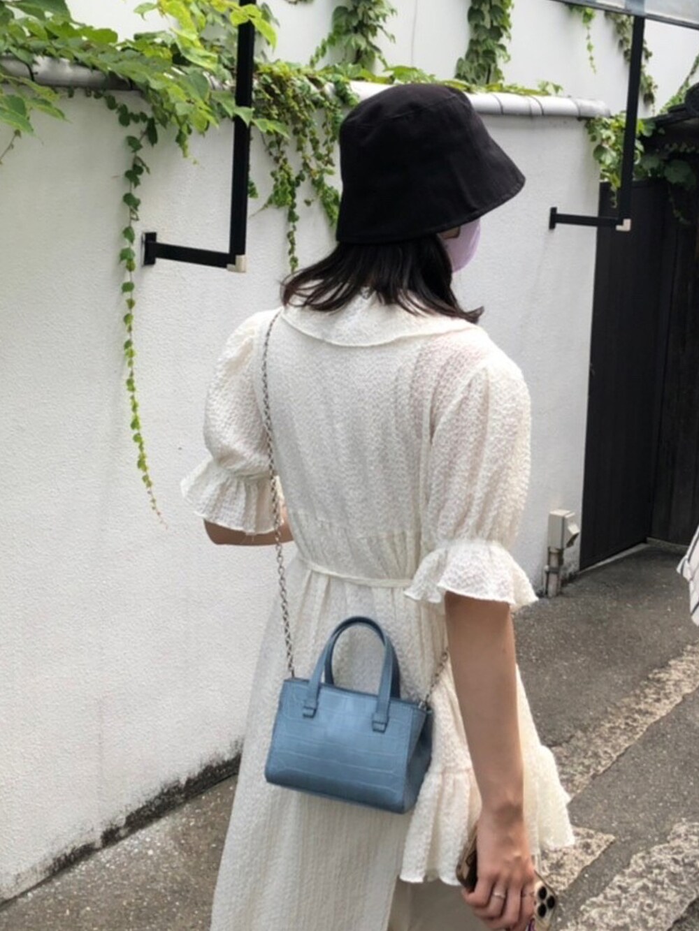 ブルー系のバッグ、ホワイト系のワンピース/ドレス、ブラック系の帽子を着用したレディースの夏コーディネートの2枚目の写真