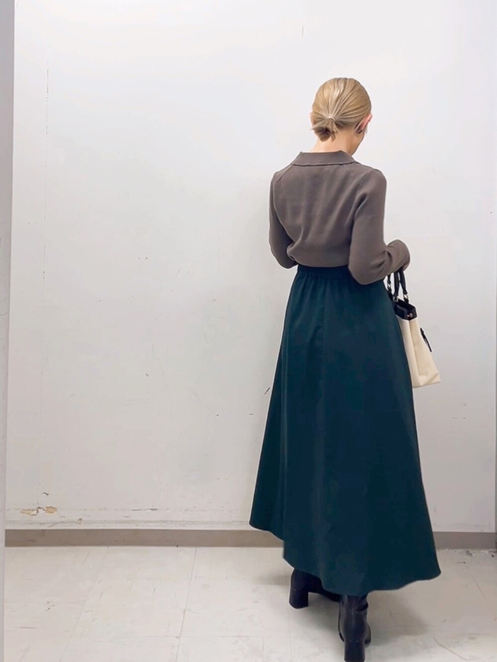 ホワイト系のハンドバッグ、ブラウン系のニット/セーター、グリーン系のスカートを着用したレディースの秋コーディネートの2枚目の写真