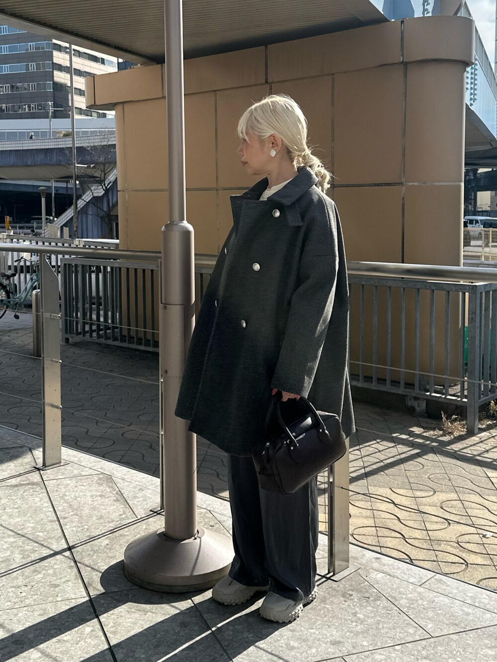 グレー系のその他アウター、グレー系のその他パンツ、ブラック系のハンドバッグを着用したレディースの冬コーディネートの4枚目の写真