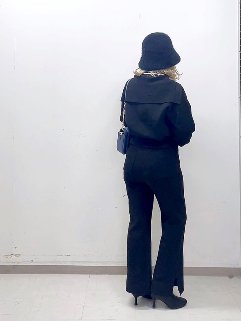 ブラック系のブーツ、ブラック系のその他パンツ、ブルー系のハンドバッグを着用したレディースの秋コーディネートの5枚目の写真