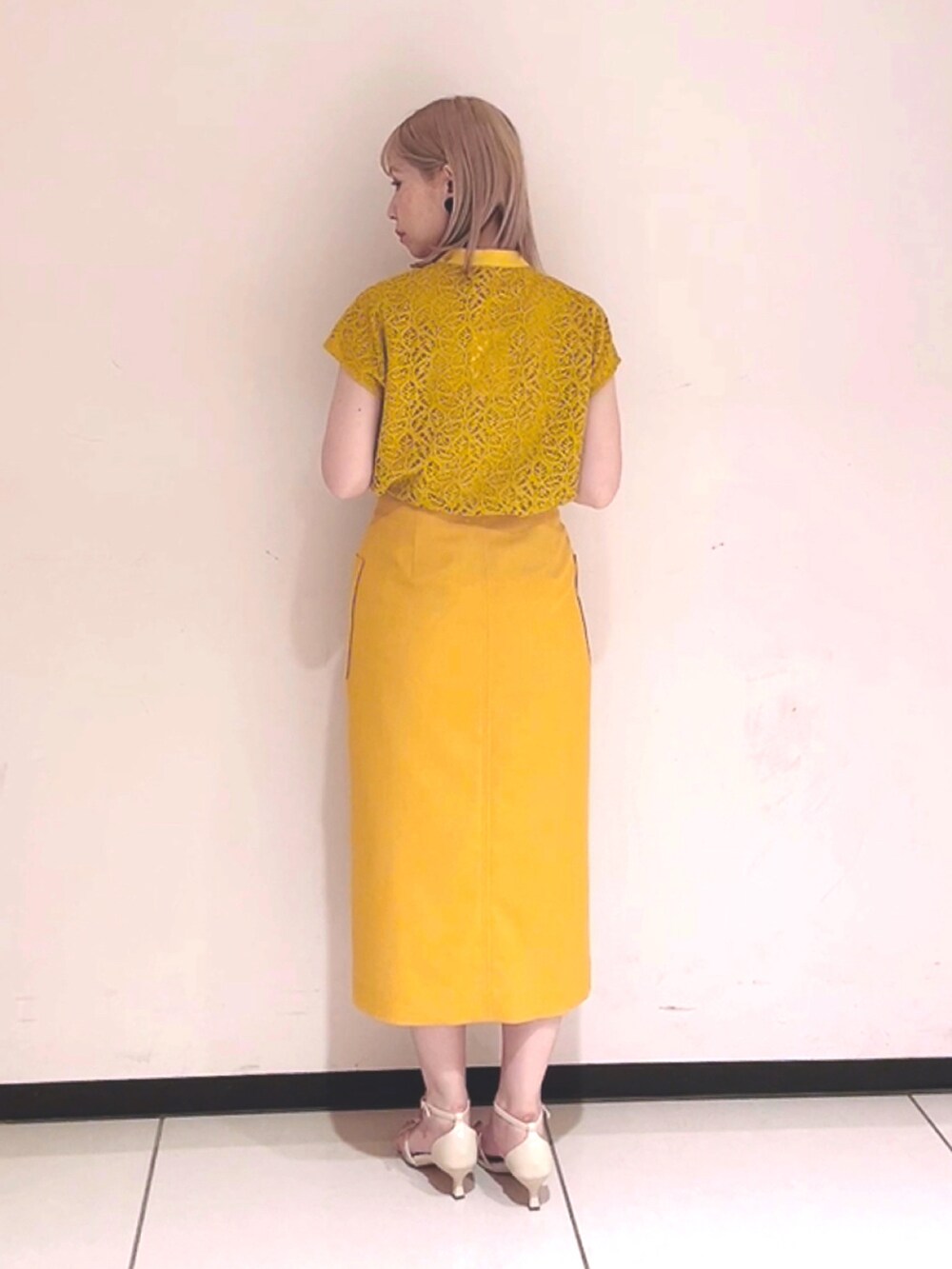 イエロー系のシャツ/ブラウス、イエロー系のスカート、ホワイト系のサンダルを着用したレディースの春コーディネートの3枚目の写真