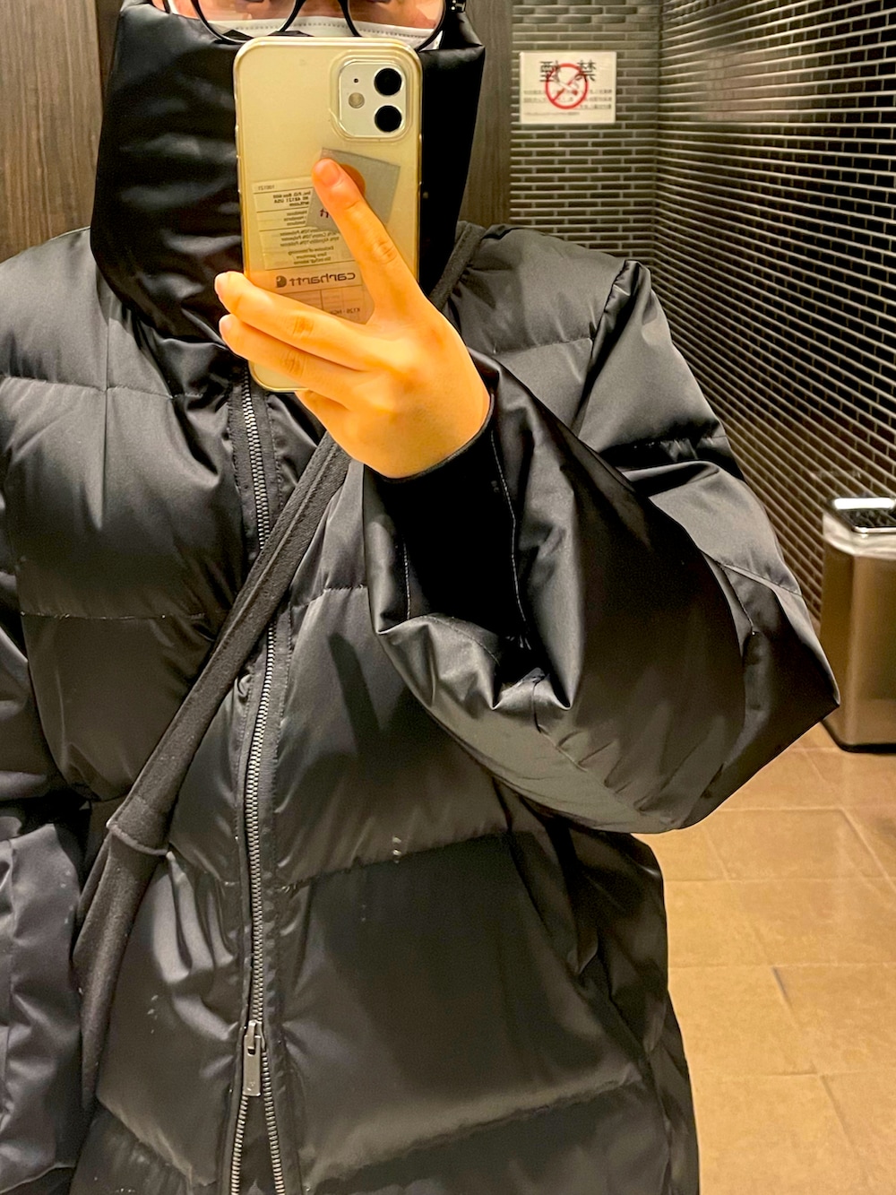 ブラック系のダウンジャケット/コート、ブラック系のショルダーバッグ、グリーン系のスラックスを着用したレディースの冬コーディネートの2枚目の写真