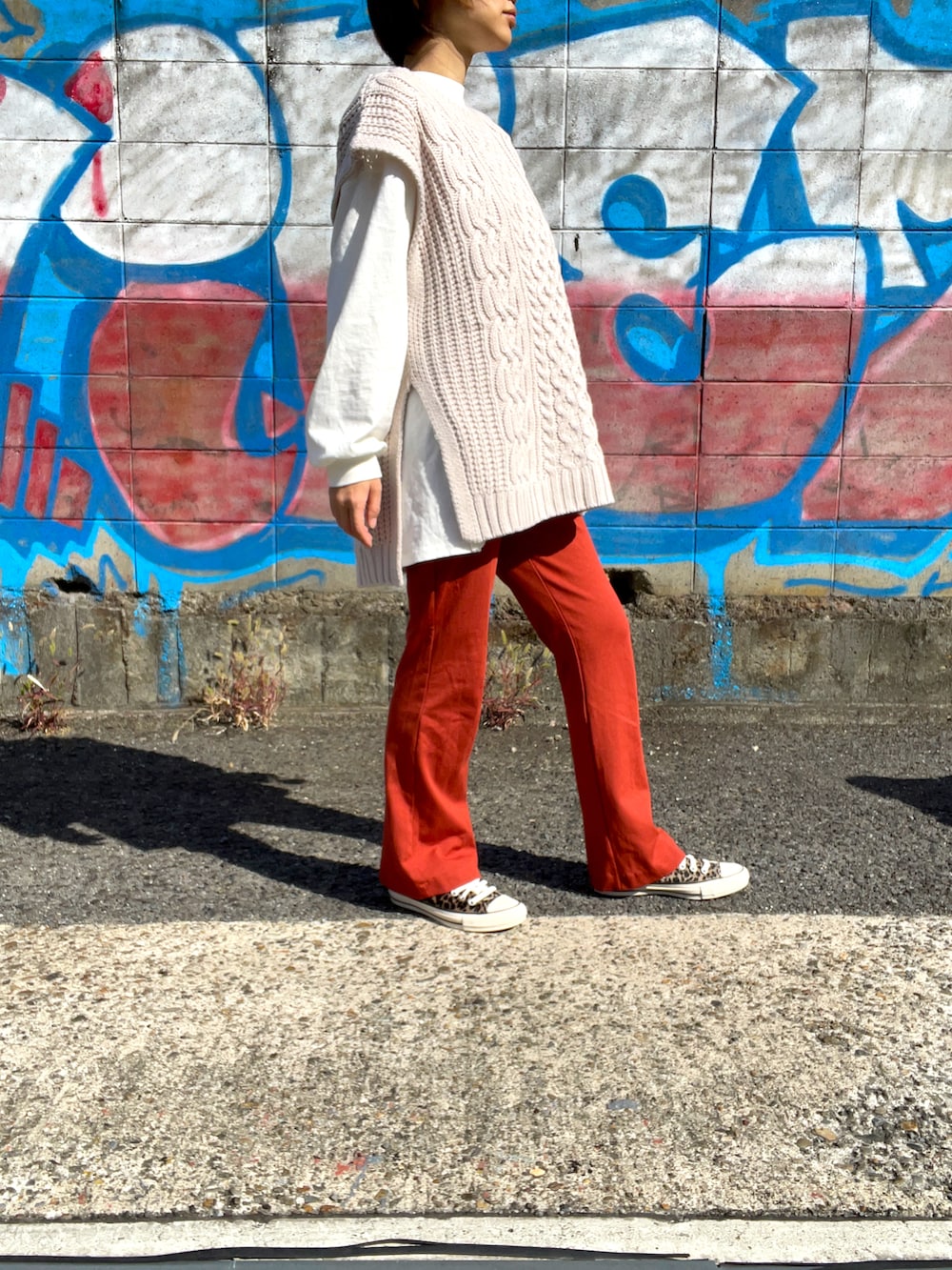 ベージュ系のベスト、ブラウン系のその他パンツ、ベージュ系のスニーカーを着用したレディースの秋コーディネートの2枚目の写真