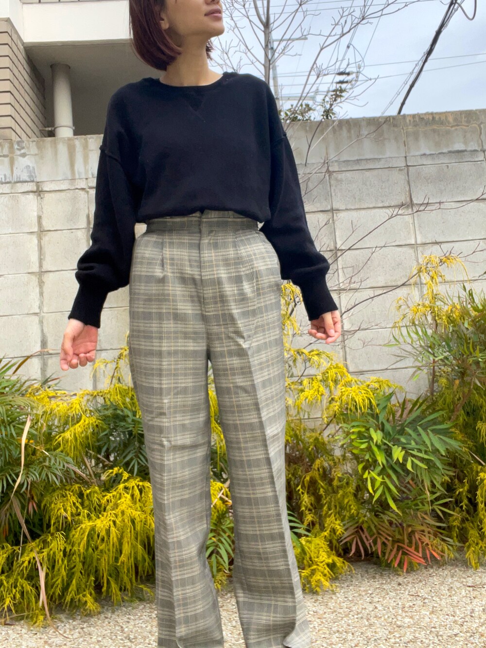 ブラック系のニット/セーター、グレー系のその他パンツを着用したレディースの春コーディネートの3枚目の写真