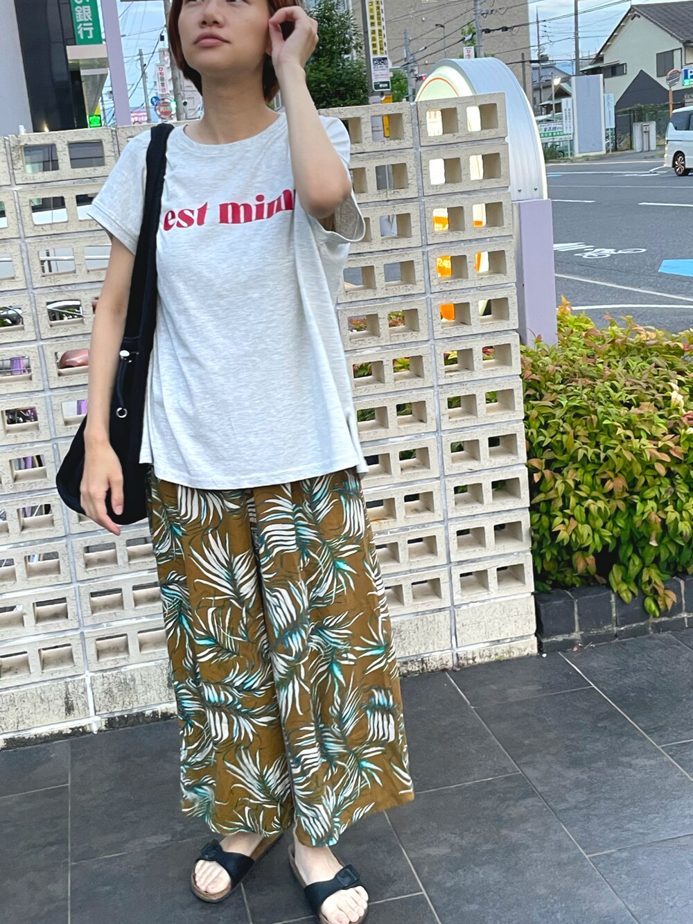 ブラック系のバッグ、その他のその他パンツ、ホワイト系のTシャツ/カットソーを着用したレディースの夏コーディネートの2枚目の写真