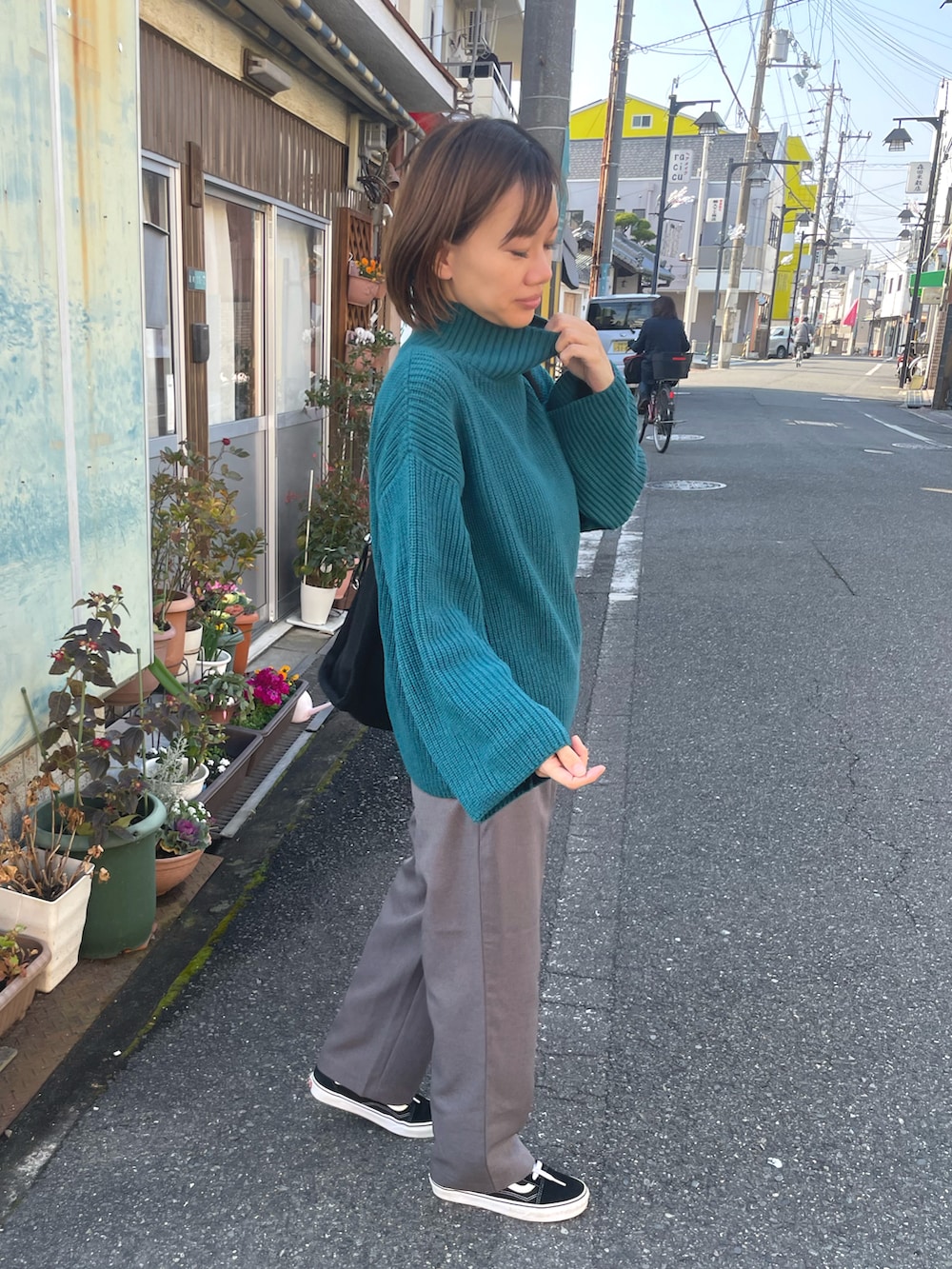 グリーン系のニット/セーター、グレー系のその他パンツを着用したレディースの冬コーディネートの2枚目の写真