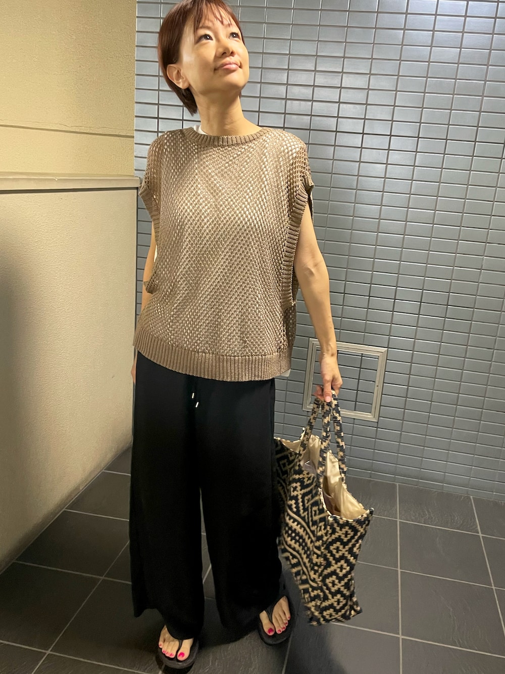 ブラック系のサンダル、ブラウン系のベスト、ブラック系のその他パンツを着用したレディースの秋コーディネートの2枚目の写真