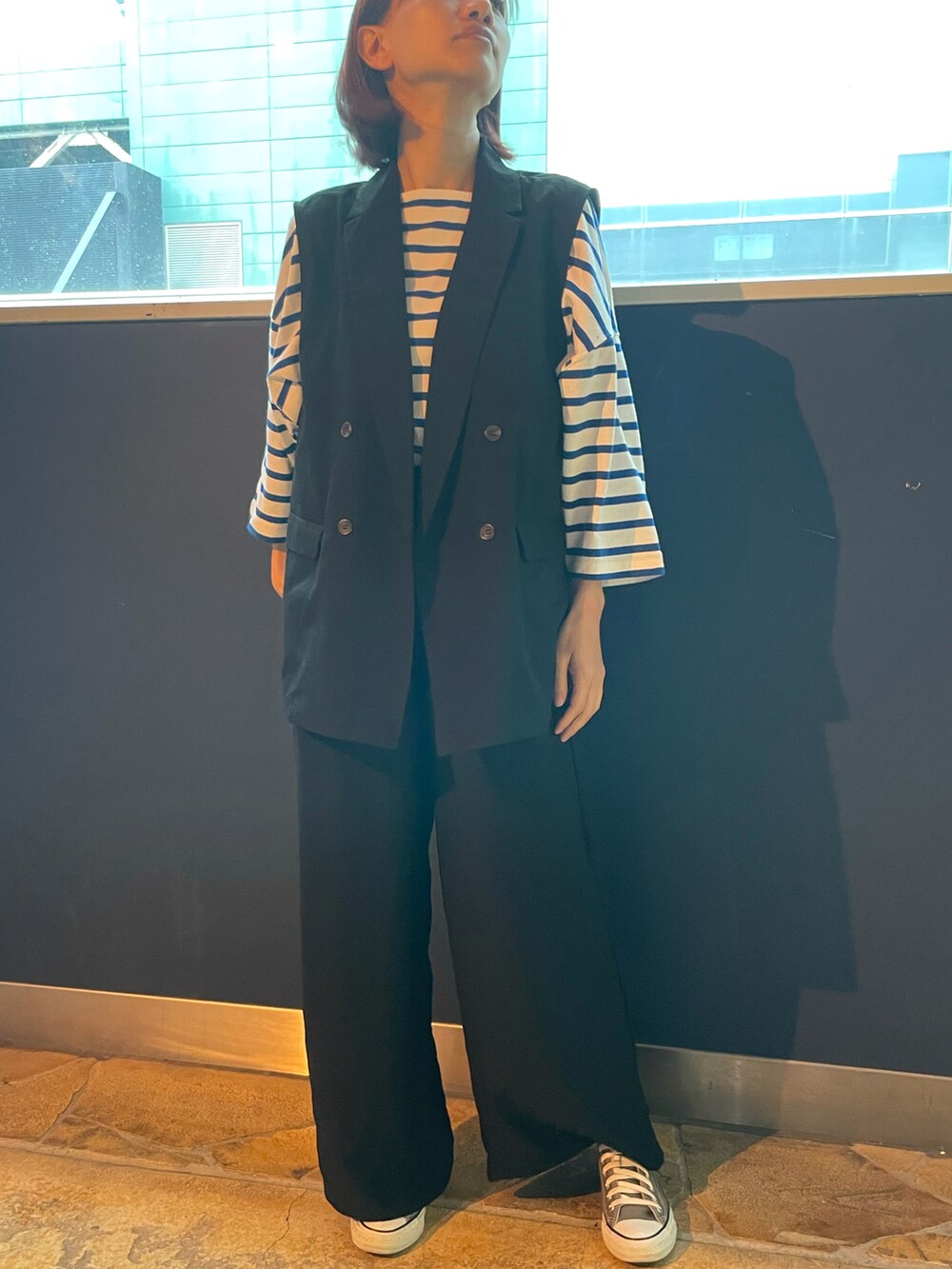 ブラック系のベスト、ブルー系のTシャツ/カットソー、ブラック系のその他パンツを着用したレディースの春コーディネートの2枚目の写真