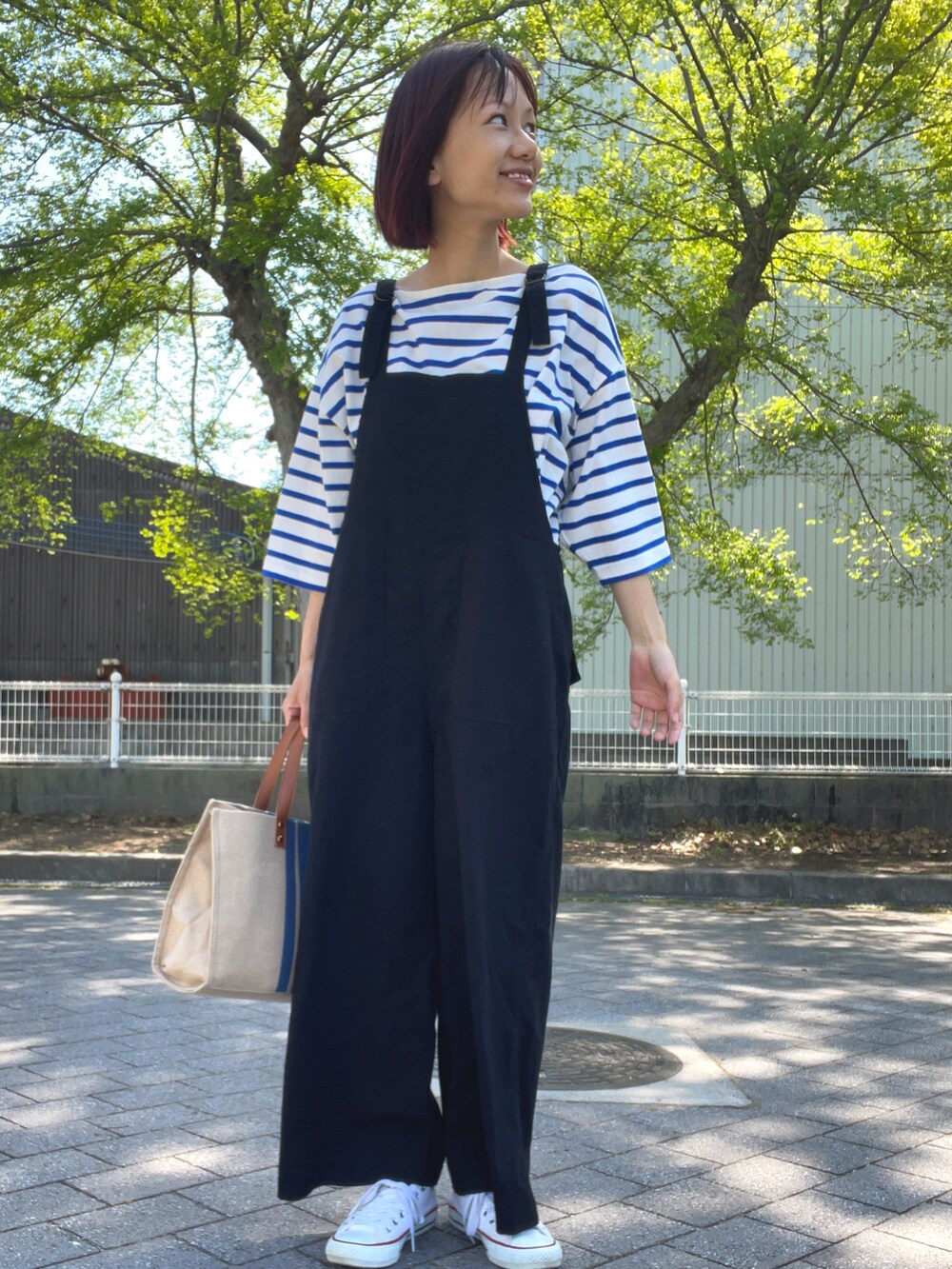 ブルー系のTシャツ/カットソー、ブラック系のサロペット/オーバーオール、ブルー系のショルダーバッグを着用したレディースの春コーディネートの2枚目の写真