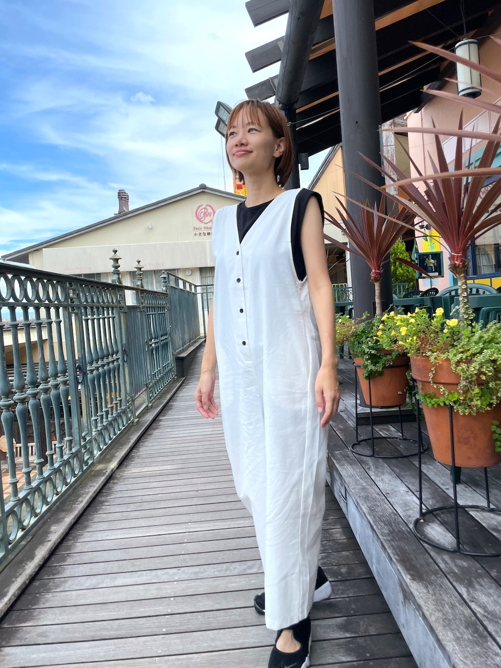 ホワイト系のサロペット/オーバーオール、ブラック系のタンクトップを着用したレディースの夏コーディネートの3枚目の写真