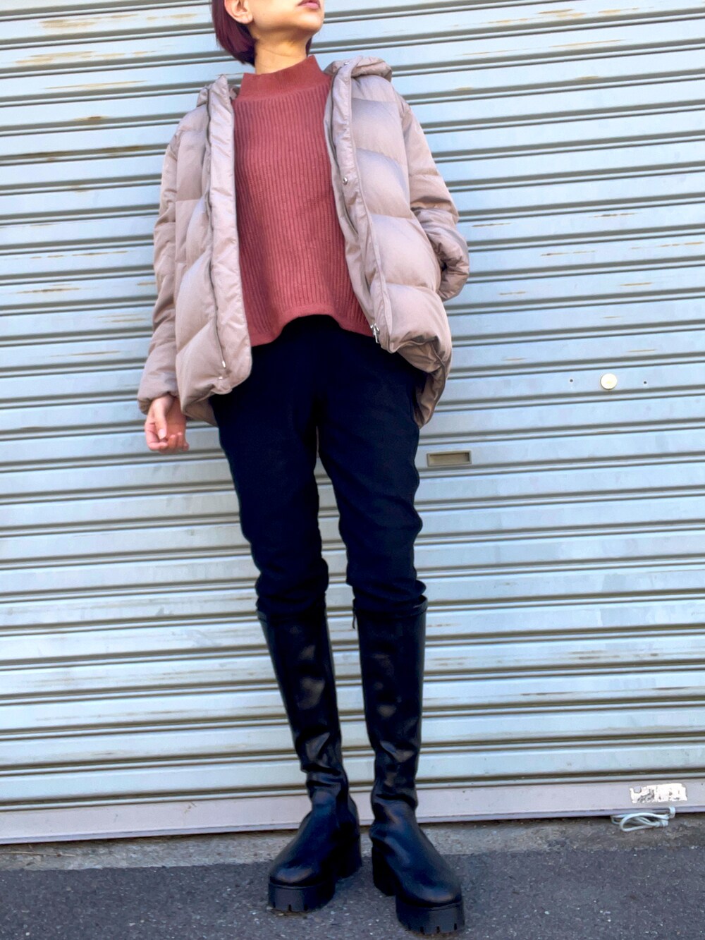 ブラック系のブーツ、ブラウン系のニット/セーター、ブラウン系のダウンジャケット/コートを着用したレディースの冬コーディネートの2枚目の写真