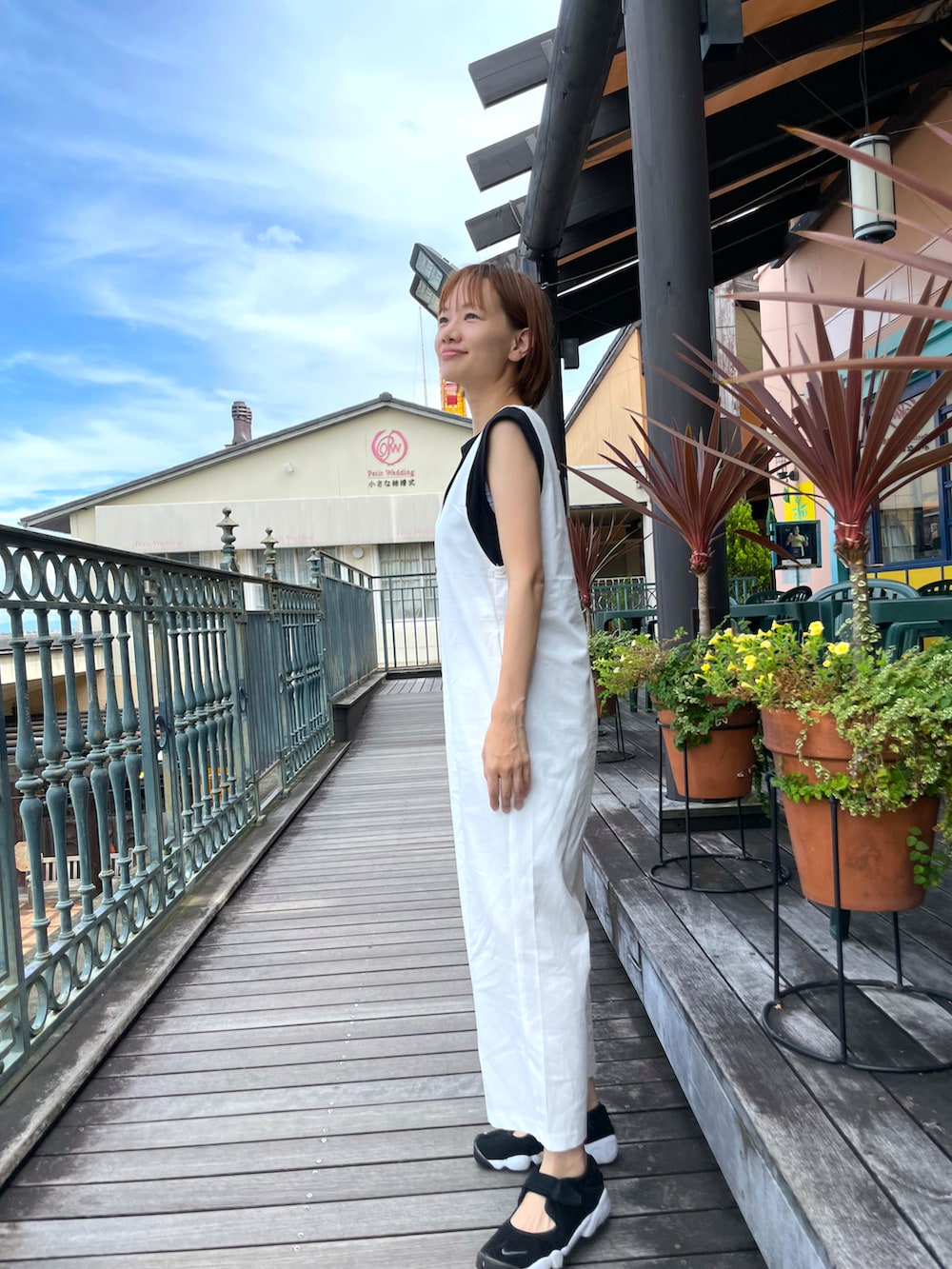 ホワイト系のサロペット/オーバーオール、ブラック系のタンクトップを着用したレディースの夏コーディネートの2枚目の写真