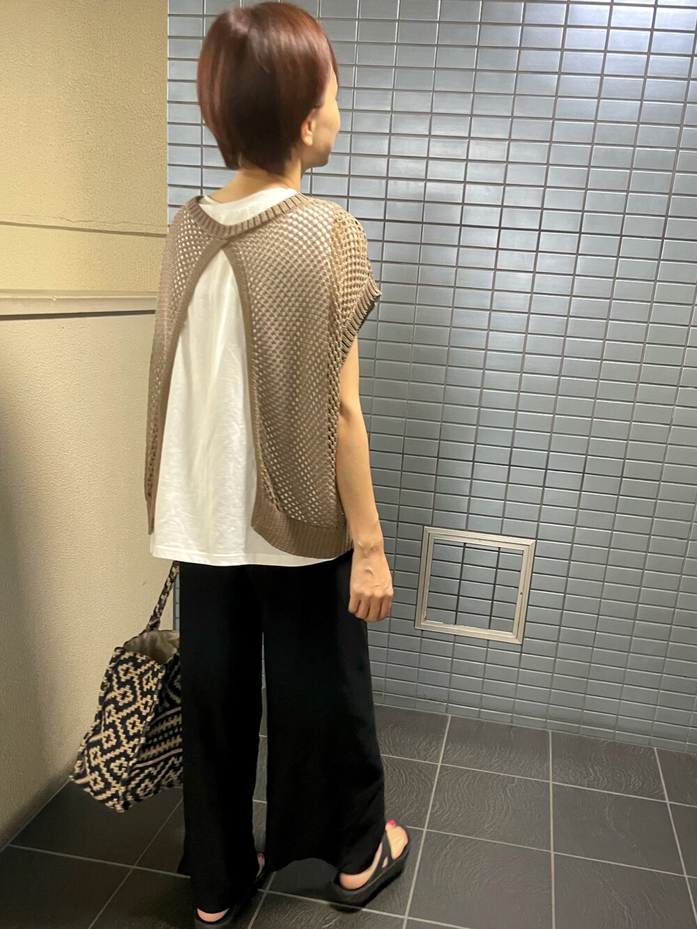 ブラック系のサンダル、ブラウン系のベスト、ブラック系のその他パンツを着用したレディースの秋コーディネートの4枚目の写真