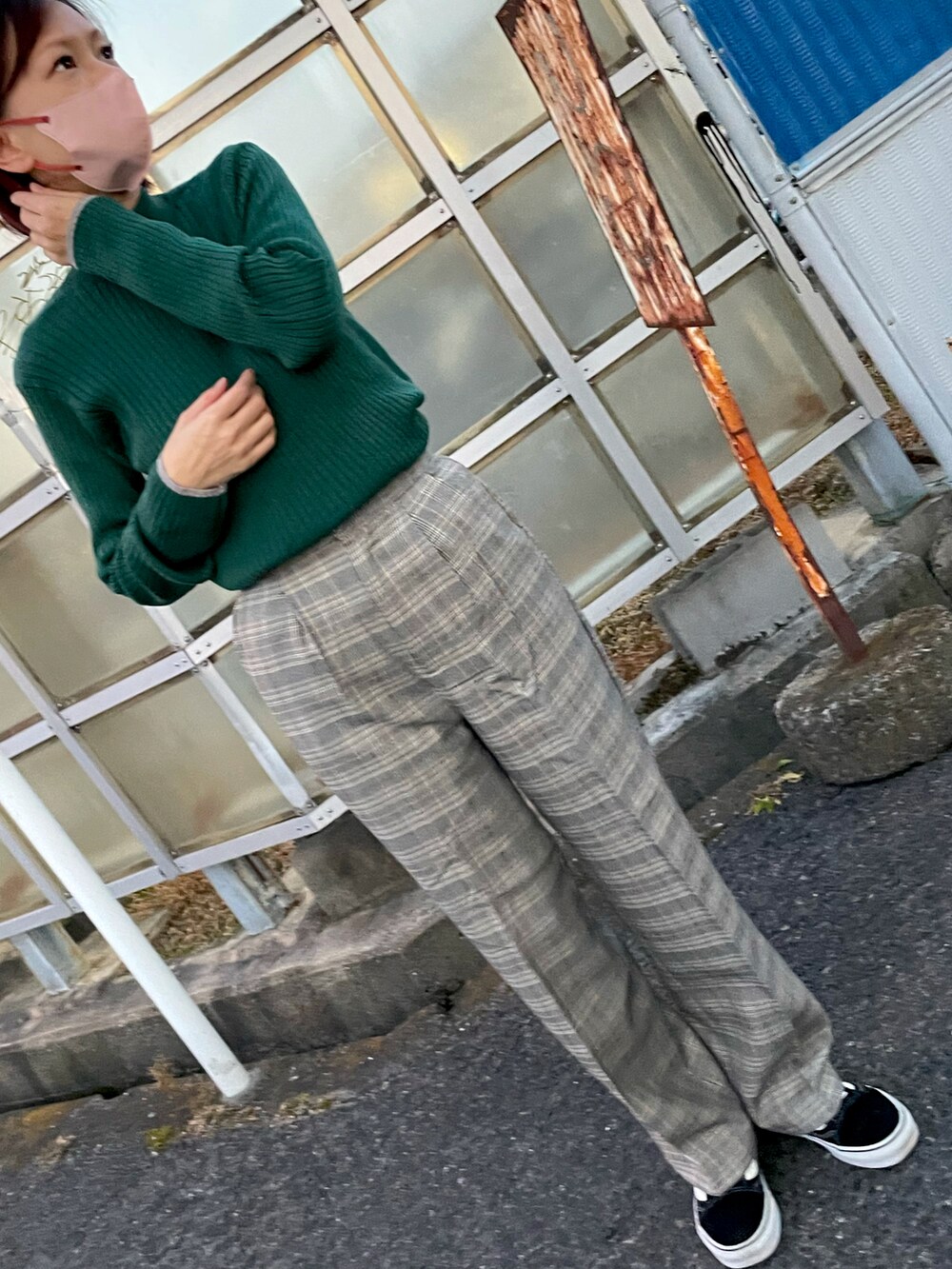 グリーン系のニット/セーター、グレー系のその他パンツ、ブラック系のスニーカーを着用したレディースの春コーディネートの3枚目の写真