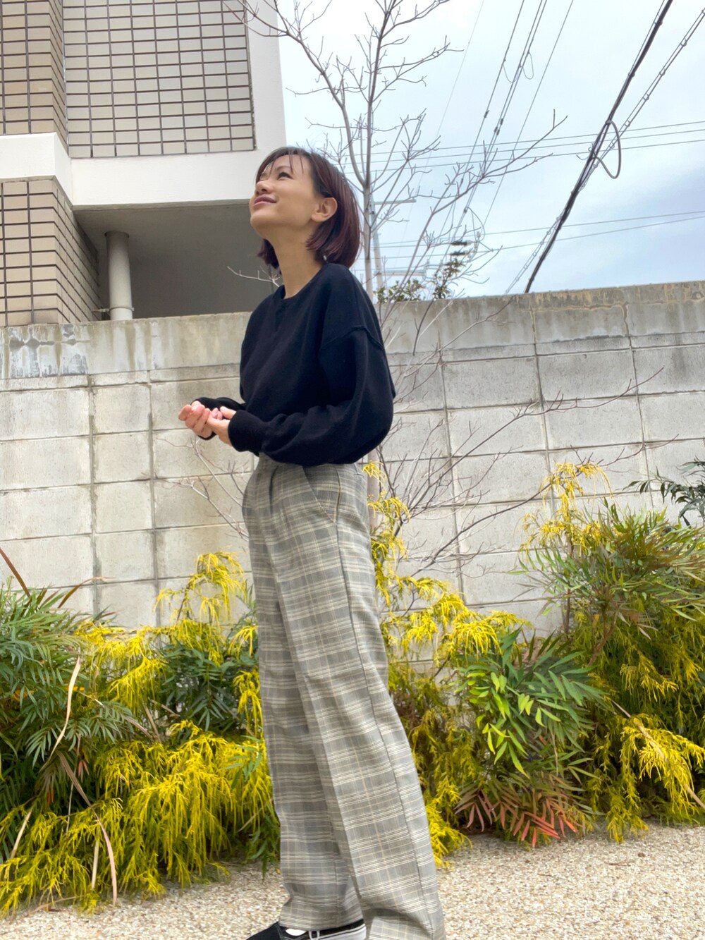 ブラック系のニット/セーター、グレー系のその他パンツを着用したレディースの春コーディネートの2枚目の写真