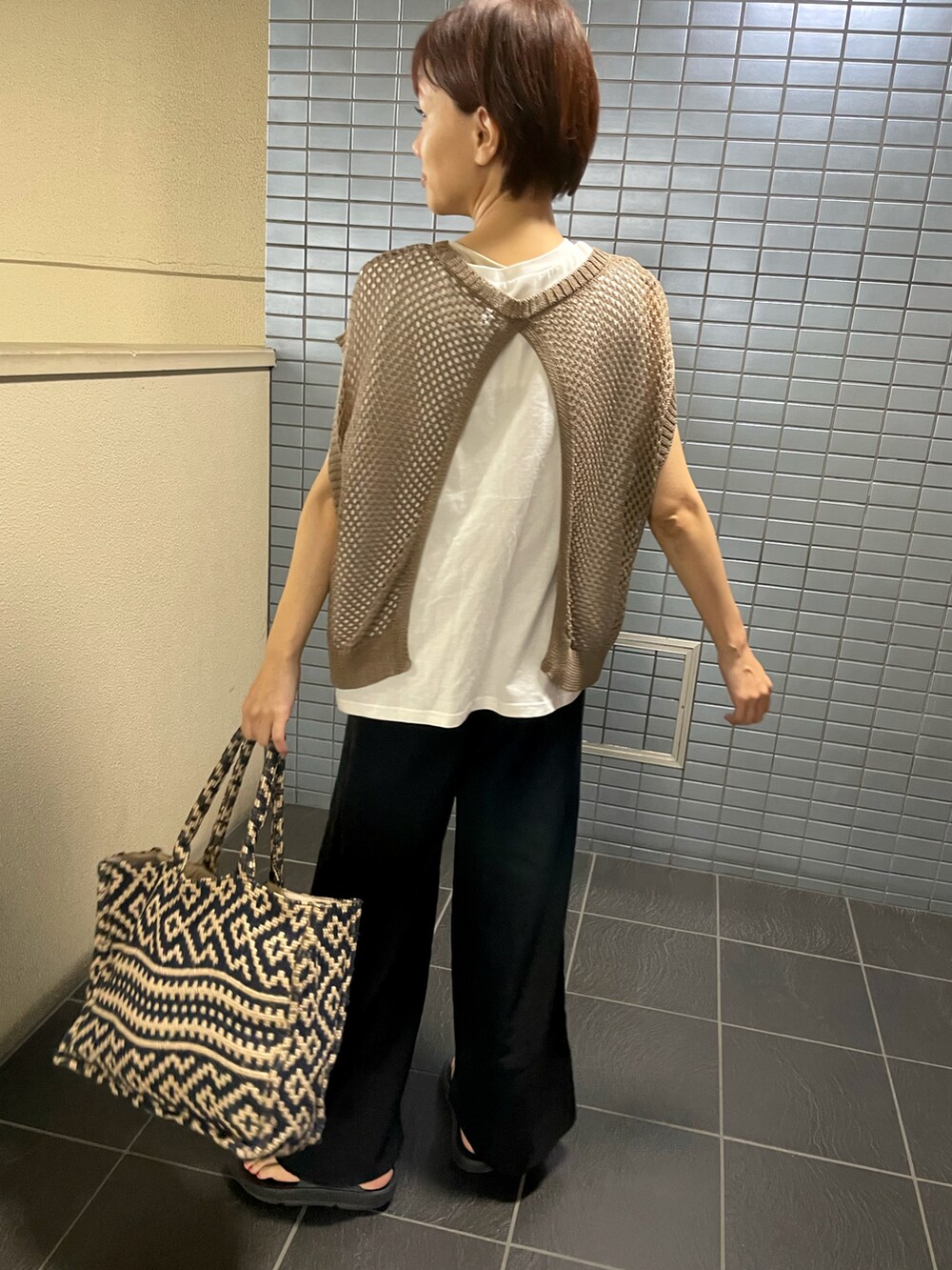 ブラック系のサンダル、ブラウン系のベスト、ブラック系のその他パンツを着用したレディースの秋コーディネートの3枚目の写真