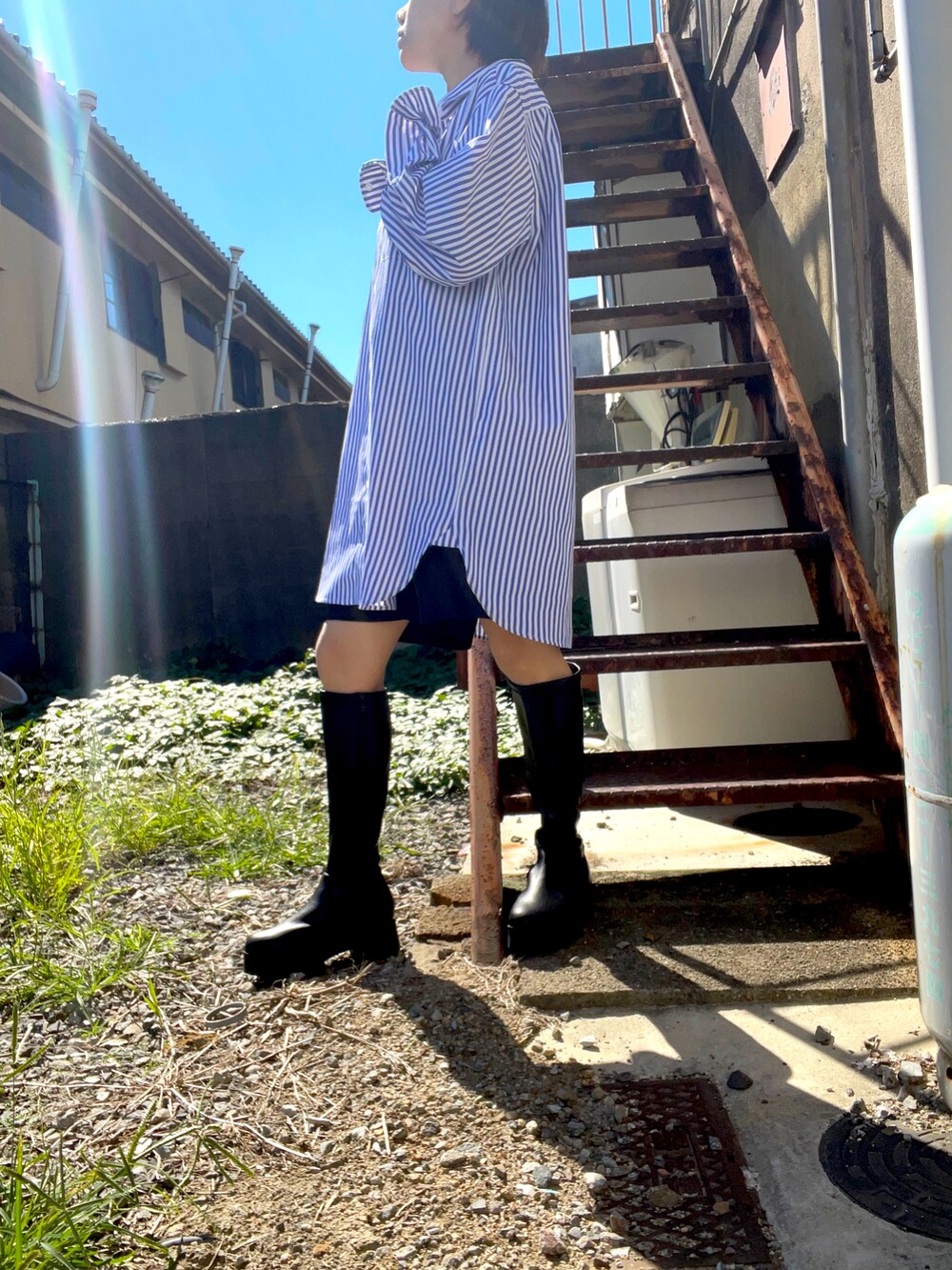 ホワイト系のシャツワンピース、ブラック系のその他パンツ、ブラック系のブーツを着用したレディースの秋コーディネートの2枚目の写真