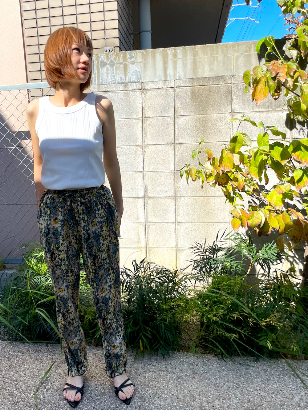 その他のその他パンツ、ブラック系のサンダル、ホワイト系のタンクトップを着用したレディースの秋コーディネートの3枚目の写真