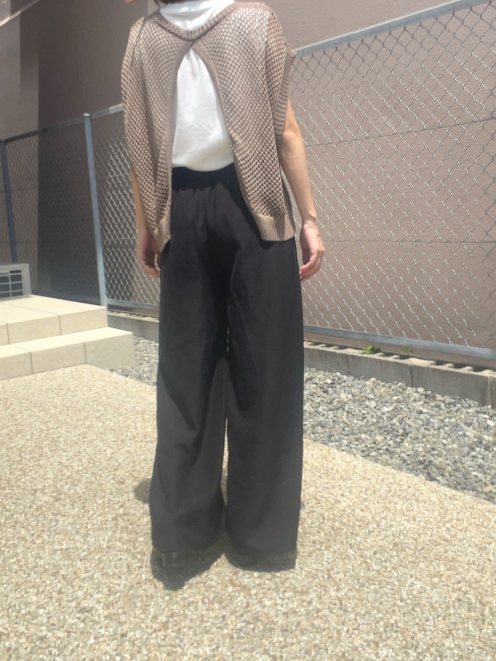 ホワイト系のTシャツ/カットソー、ブラウン系のベスト、ブラック系のサンダルを着用したレディースの夏コーディネートの2枚目の写真