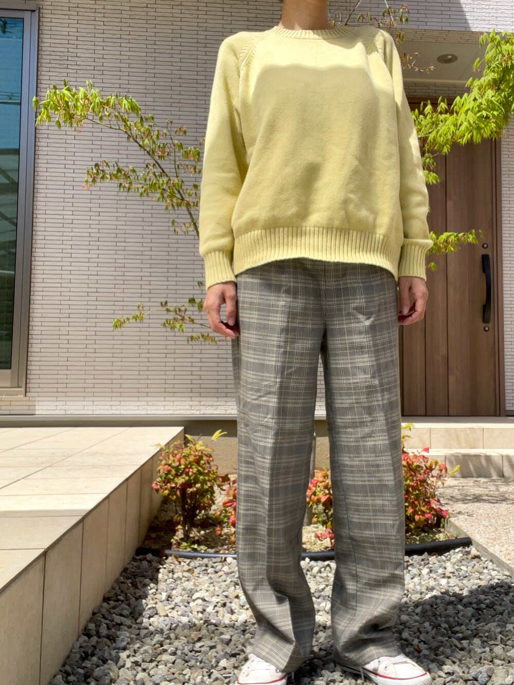 グレー系のその他パンツ、イエロー系のニット/セーター、ホワイト系のスニーカーを着用したレディースの春コーディネートの3枚目の写真