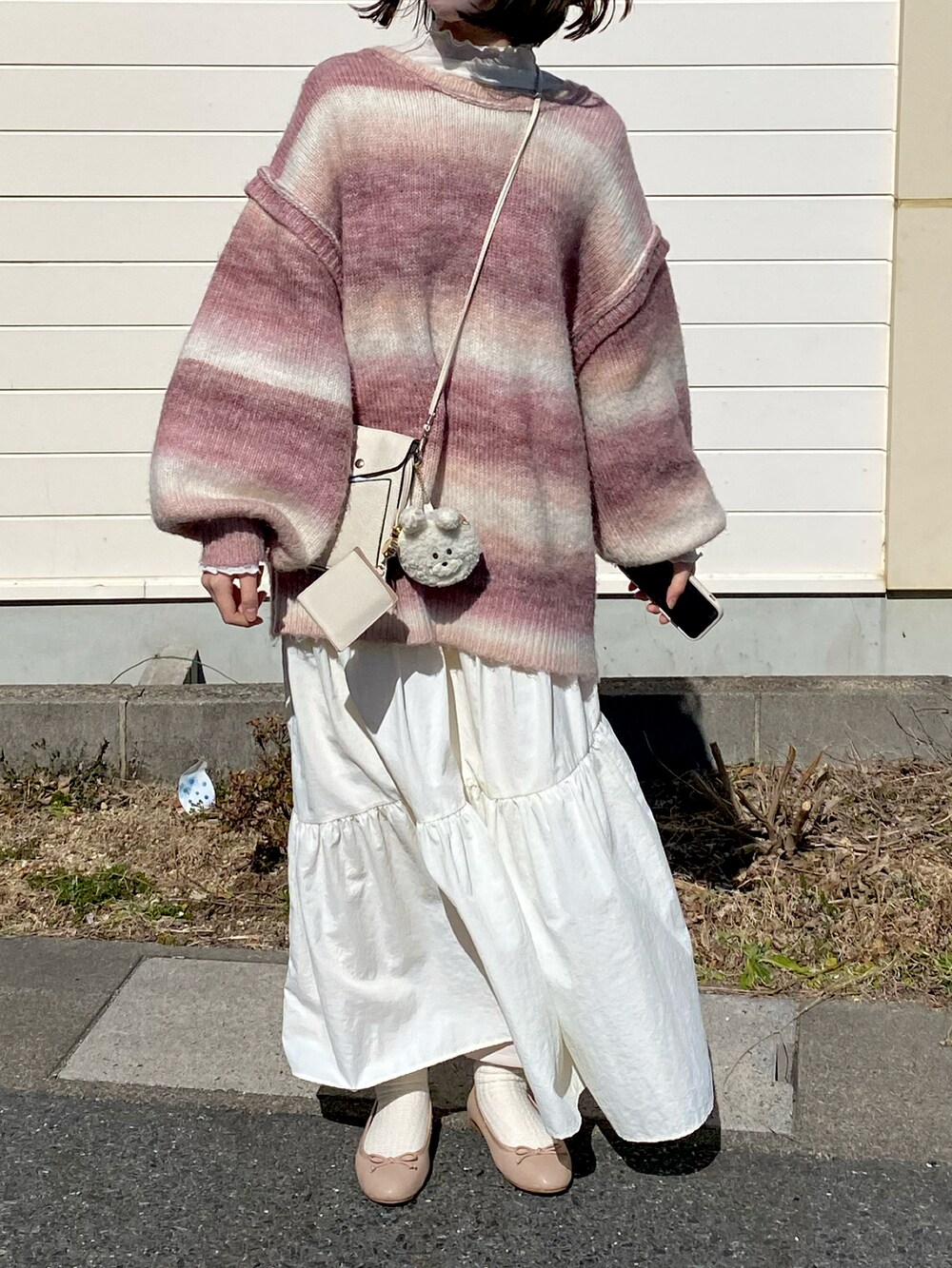 ピンク系のカーディガン/ボレロ、ホワイト系のスカート、ホワイト系のバッグを着用したレディースの春コーディネートの2枚目の写真