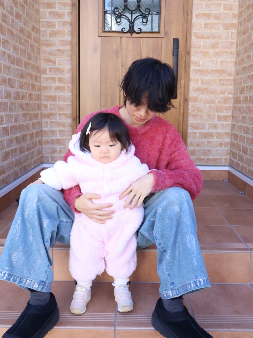 ピンク系のスニーカー、ブラック系のその他シューズ、ブルー系のデニムパンツを着用したキッズの冬コーディネートの2枚目の写真