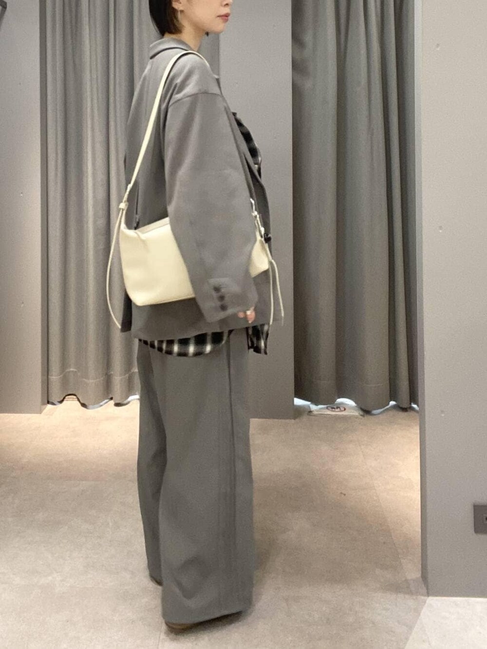 ホワイト系のショルダーバッグ、グレー系のその他パンツ、グレー系のテーラードジャケットを着用したレディースの冬コーディネートの3枚目の写真