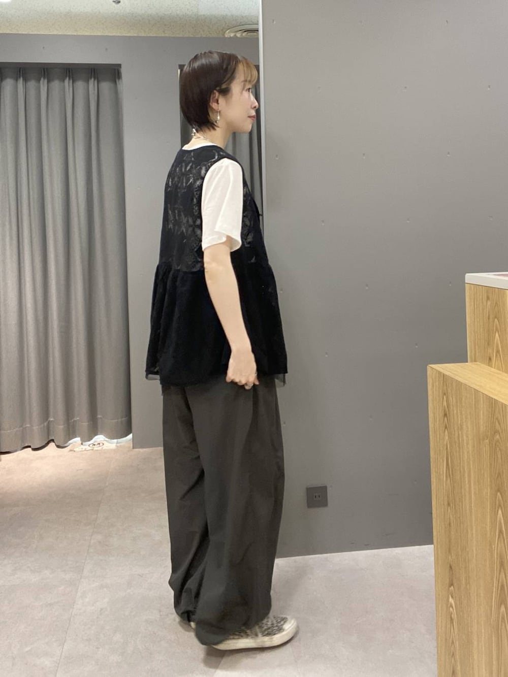 ブラック系のベスト、グレー系のその他パンツ、ホワイト系のTシャツ/カットソーを着用したレディースの夏コーディネートの2枚目の写真