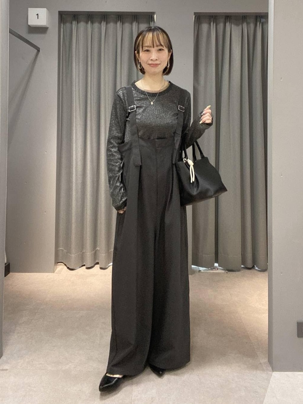 グレー系のサロペット/オーバーオール、ブラック系のトートバッグ、ブラック系のパンプスを着用したレディースの春コーディネートの3枚目の写真