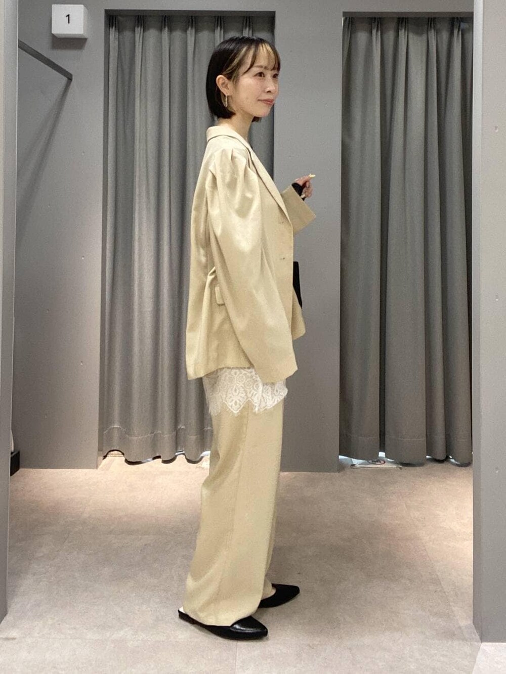 ベージュ系のその他パンツ、ベージュ系のその他アウター、ブラック系のトートバッグを着用したレディースの春コーディネートの2枚目の写真