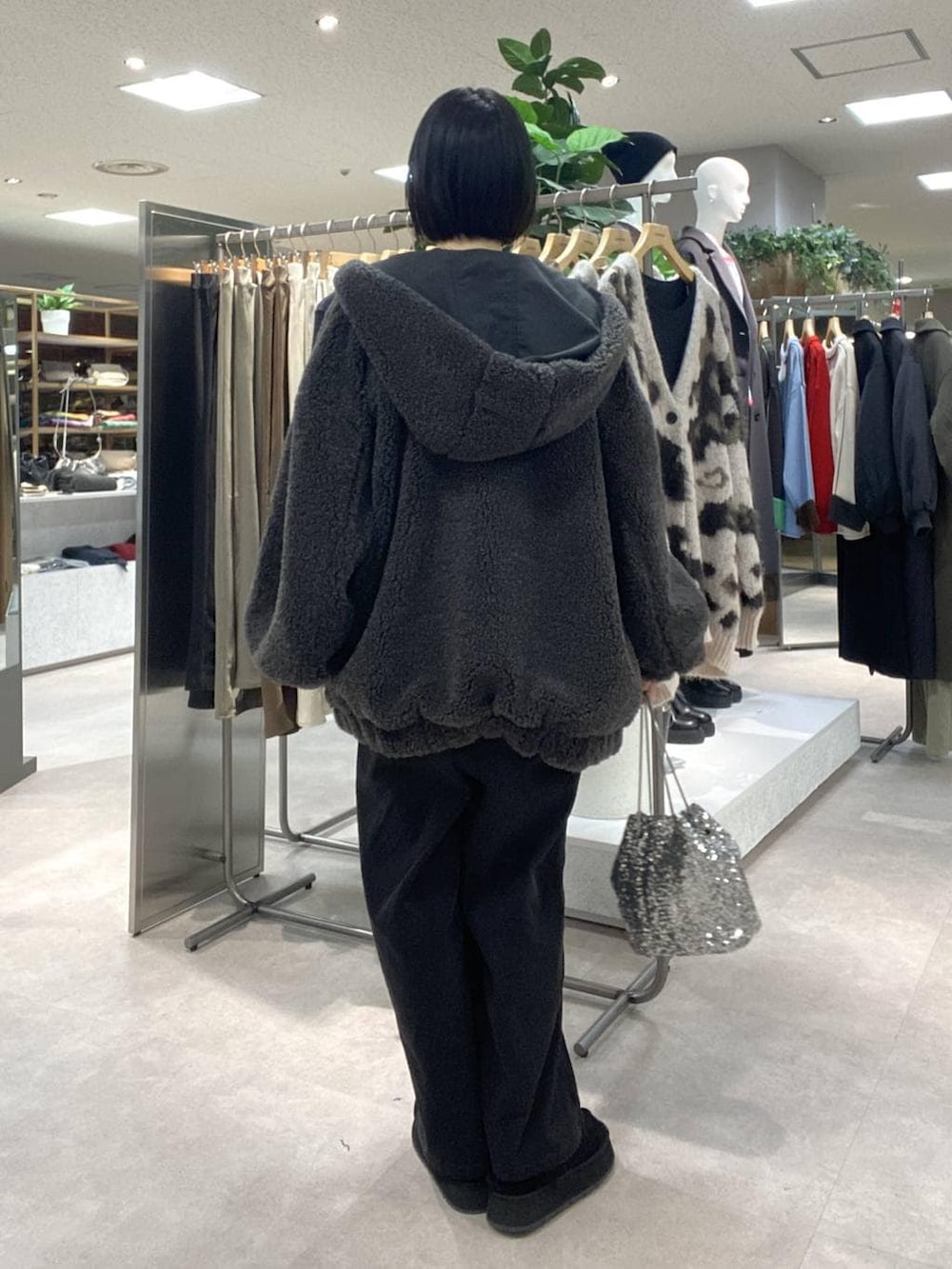 レッド系のニット/セーター、シルバー系のショルダーバッグ、グレー系のサロペット/オーバーオールを着用したレディースの冬コーディネートの3枚目の写真