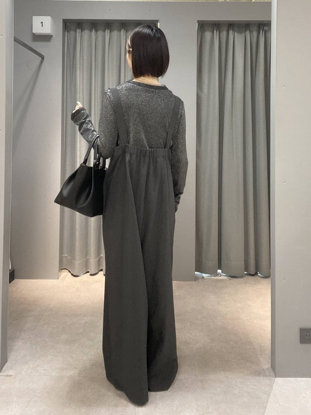 グレー系のサロペット/オーバーオール、ブラック系のトートバッグ、ブラック系のパンプスを着用したレディースの春コーディネートの2枚目の写真