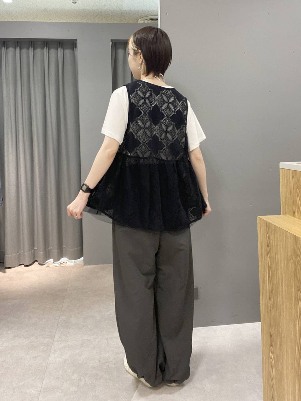 ブラック系のベスト、グレー系のその他パンツ、ホワイト系のTシャツ/カットソーを着用したレディースの夏コーディネートの3枚目の写真