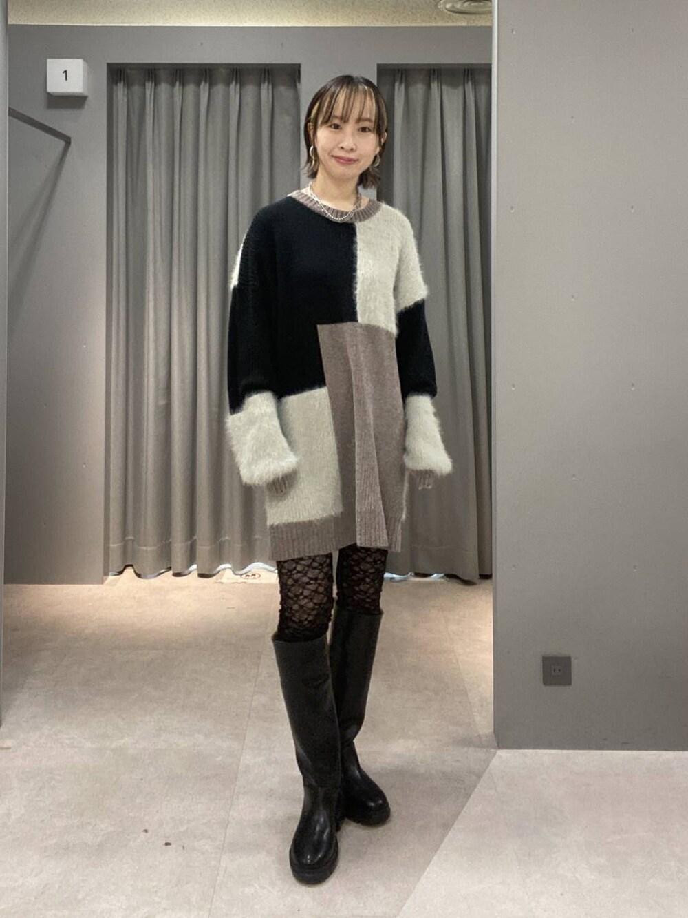 ブラック系のブーツ、ブラック系のショルダーバッグ、グレー系のニット/セーターを着用したレディースの秋コーディネートの4枚目の写真
