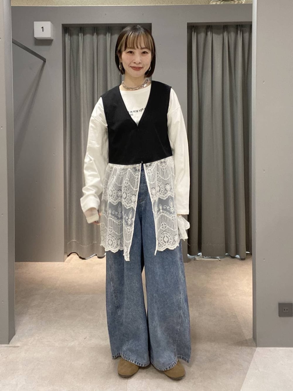 ホワイト系のパーカー、ブルー系のデニムパンツ、ホワイト系のボストンバッグを着用したレディースの春コーディネートの4枚目の写真