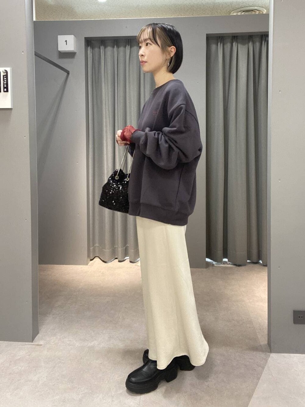 レッド系のTシャツ/カットソー、ホワイト系のスカート、ブラック系のブーツを着用したレディースの秋コーディネートの2枚目の写真