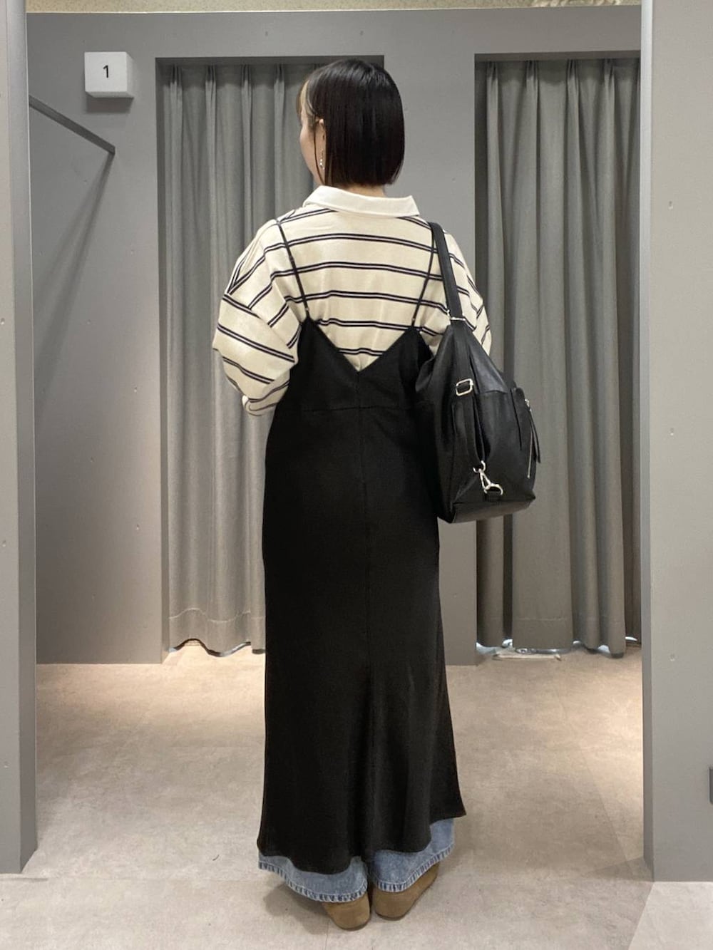 ブラック系のショルダーバッグ、ブルー系のデニムパンツ、ブラウン系のスニーカーを着用したレディースの春コーディネートの3枚目の写真