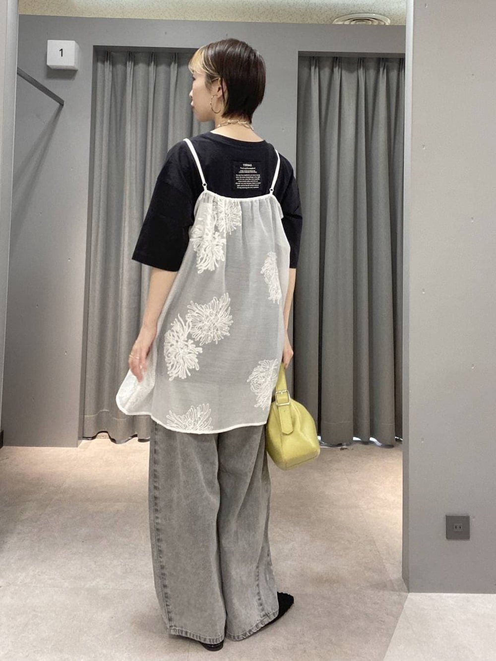 ブラック系のTシャツ/カットソー、イエロー系のショルダーバッグ、ブラック系のパンプスを着用したレディースの夏コーディネートの2枚目の写真