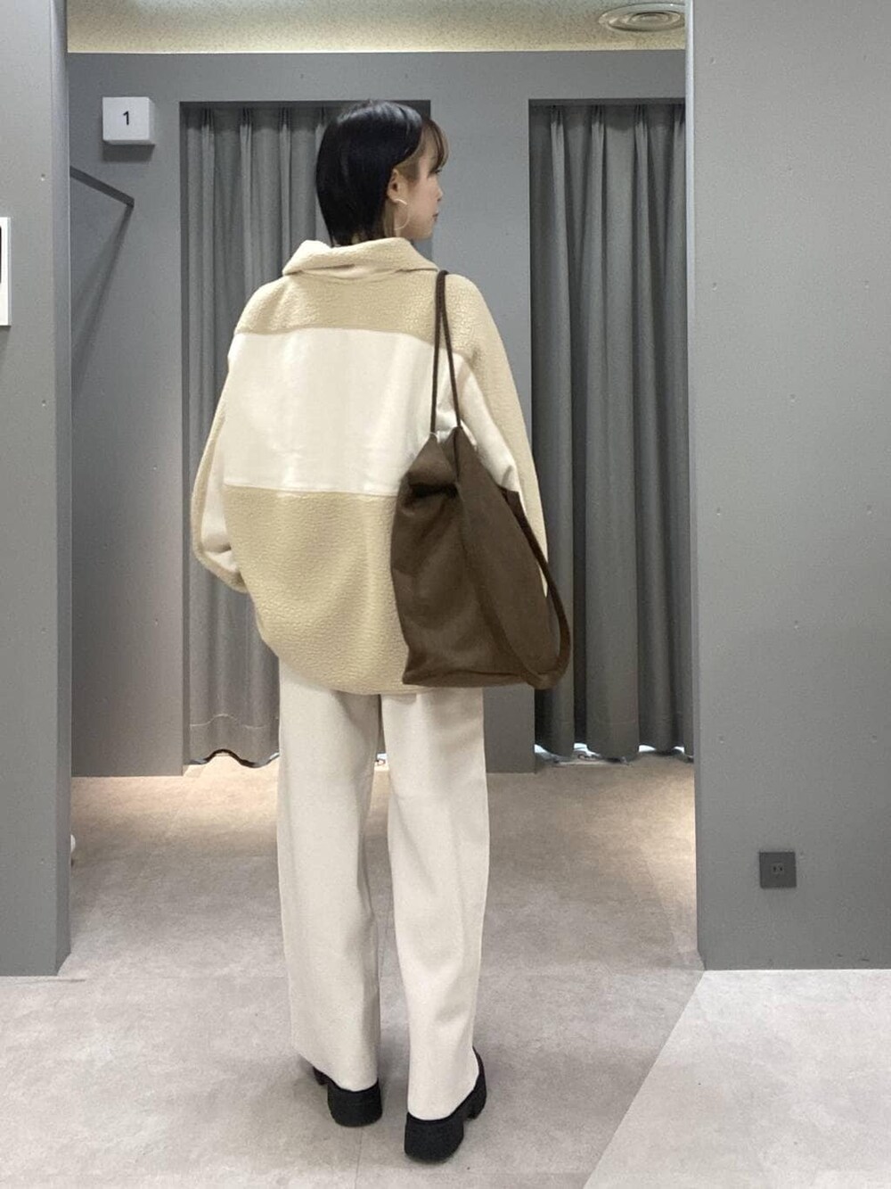 ベージュ系のその他パンツ、ブラウン系のトートバッグ、シルバー系のネックレスを着用したレディースの秋コーディネートの3枚目の写真