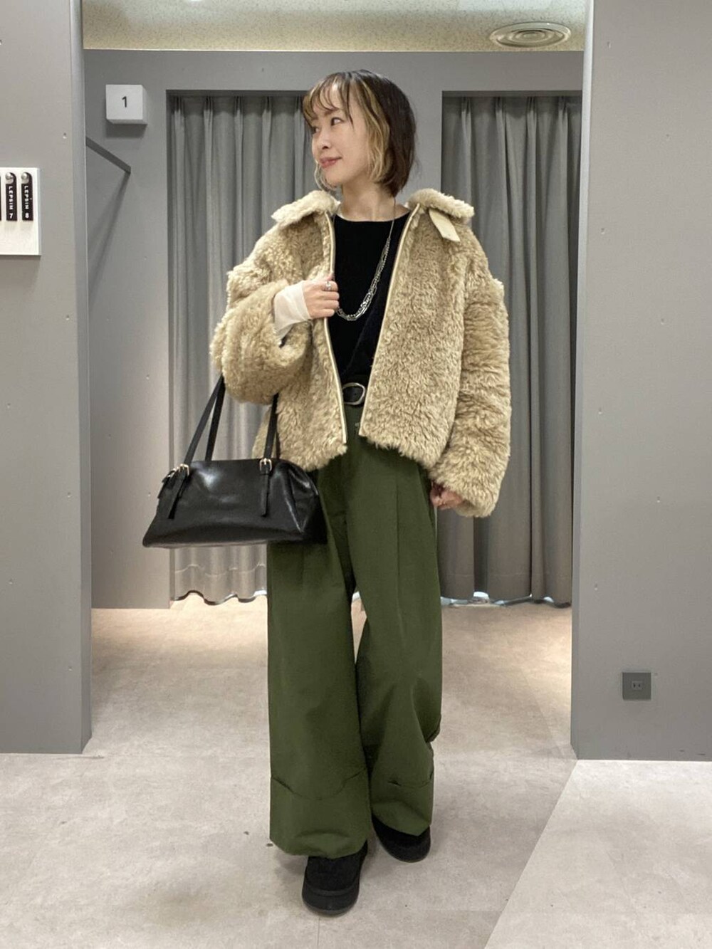 ブラック系のボストンバッグ、グリーン系のその他パンツ、ベージュ系のブルゾンを着用したレディースの秋コーディネートの2枚目の写真