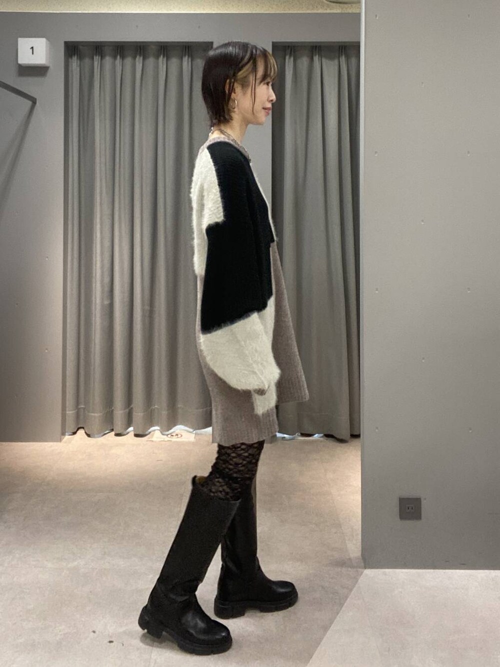 ブラック系のブーツ、ブラック系のショルダーバッグ、グレー系のニット/セーターを着用したレディースの秋コーディネートの5枚目の写真