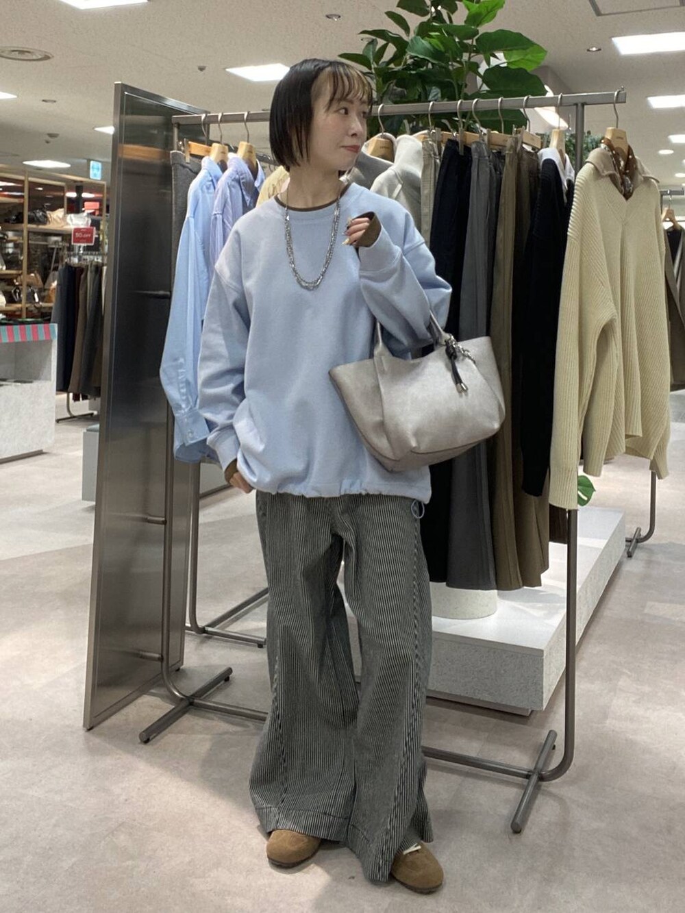 ブルー系のその他パンツ、ベージュ系のトレンチコート、ブラウン系のスニーカーを着用したレディースの冬コーディネートの4枚目の写真