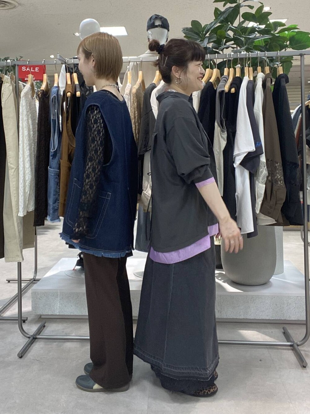 ブラック系のデニムスカート、グレー系のシャツ/ブラウス、ホワイト系のTシャツ/カットソーを着用したレディースの夏コーディネートの2枚目の写真
